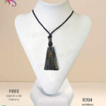 Red clay pendant made by hand with triangular shape and simple engraving on it.