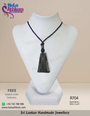 Red clay pendant made by hand with triangular shape and simple engraving on it.