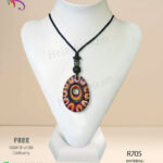 Egg shaped red clay pendant with colourful patterns and engravings on it.