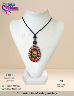 Egg shaped red clay pendant with colourful patterns and engravings on it.