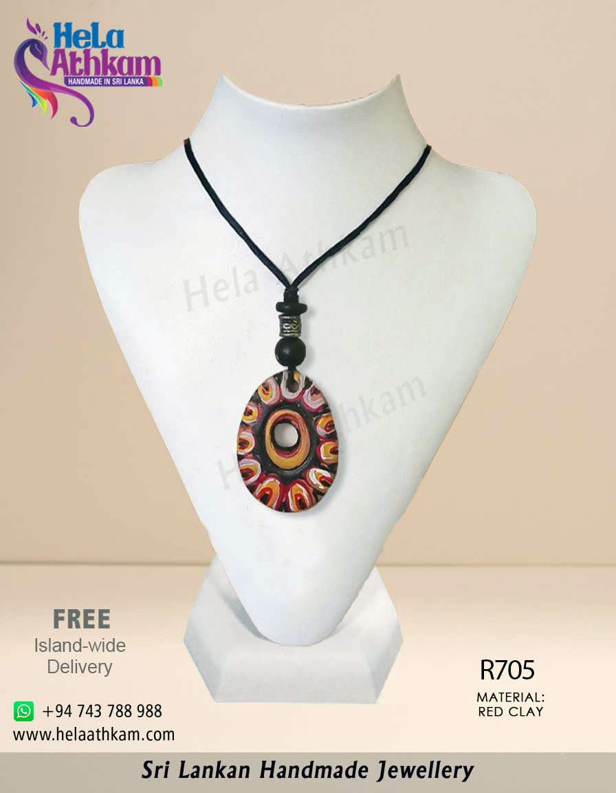 Egg shaped red clay pendant with colourful patterns and engravings on it.