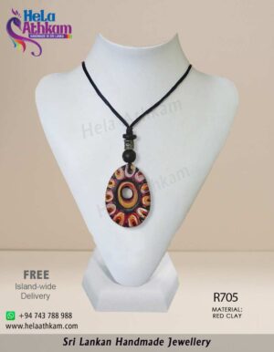 Egg shaped red clay pendant with colourful patterns and engravings on it.